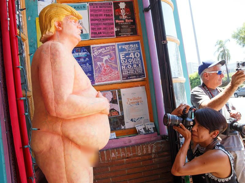 Una estatua desnuda del candidato republicano Donald Trump llama la atención de varios transeúntes quienes se fotografían con ella en Los Ángeles (EE.UU.).   /  Foto: EFE
