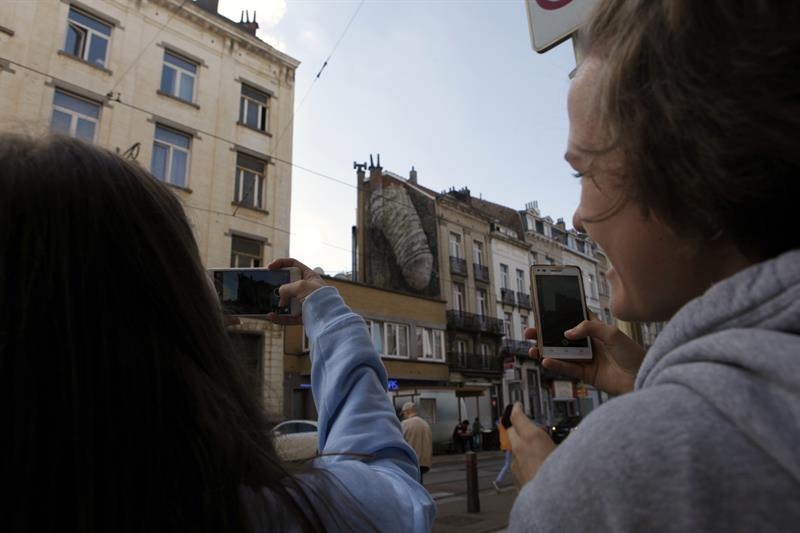 Dos personas fotografían uno de los grafitis de alto contenido sexual que han aparecido esta semana en Bruselas.  /  Foto: EFE