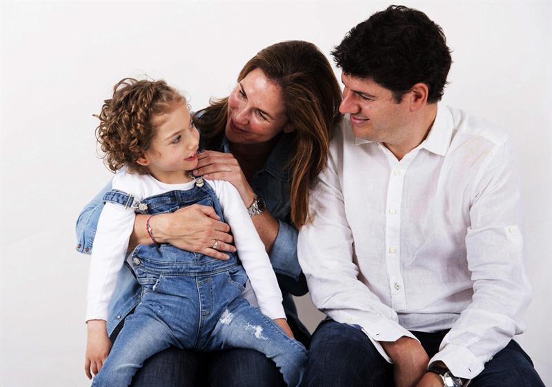 Fotografía facilitada por los padres de Mencía (i), Isabel Lavín (c) y Valero Soler (d), en la que aparecen junto a su hija de 7 años, que solo sonríe ya que no habla, ni apenas se mueve.  /  Foto: EFE