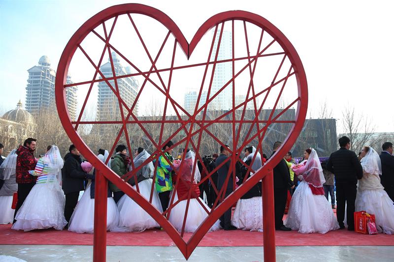 Parejas asisten a una ceremonia de bodas masiva en el 33º Festival Internacional de Hielo y Nieve de Harbin en Harbin, provincia de Heilongjiang, (China) hoy, viernes 6. EFE