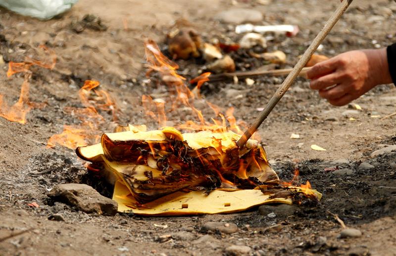 Un hombre quema papel a las afueras de Pekín, China. EFE/Archivo
