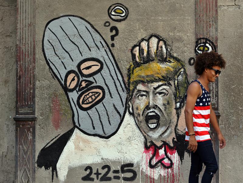 Fotografía de un grafiti de un encapuchado sosteniendo la cabeza decapitada del presidente estadounidense, Donald Trump, este 29 de junio de 2017, en la pared de una transitada calle de La Habana Vieja, en La Habana (Cuba). EFE
