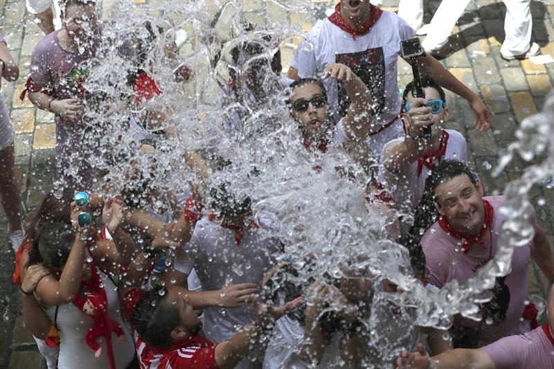 Gente recibe agua desde los balcones y festejan el inicio de las fiestas de San Fermín 2017 hoy tras el lanzamiento del tradicional chupinazo desde el balcón del Ayuntamiento de Pamplona. EFE