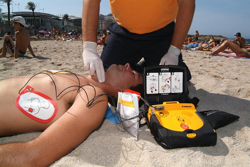 Un miembro de Protección Civil practica un simulacro del uso de un desfibrilador semiautomático externo (DESA) para los paros cardiacos en la playa de Riazor en A Coruña (España). EFE/Archivo