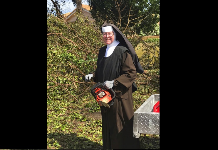 La hermana Margaret Ann corta árboles derribados por el huracán Irma, en Miami, Florida, el 12 de septiembre de 2017. (Foto Policía de Miami-Dade - vía AP)