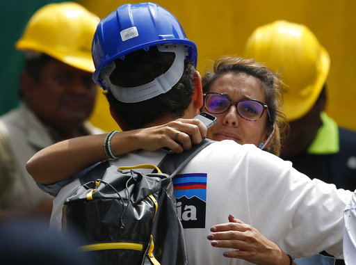 Un trabajador de rescate abraza a la novia de Jorge Gómez, de España, que espera en el sitio de búsqueda de personas que se cree están atrapadas bajo los escombros de un edificio de oficinas colapsado, incluido su novio.  /  Foto: AP