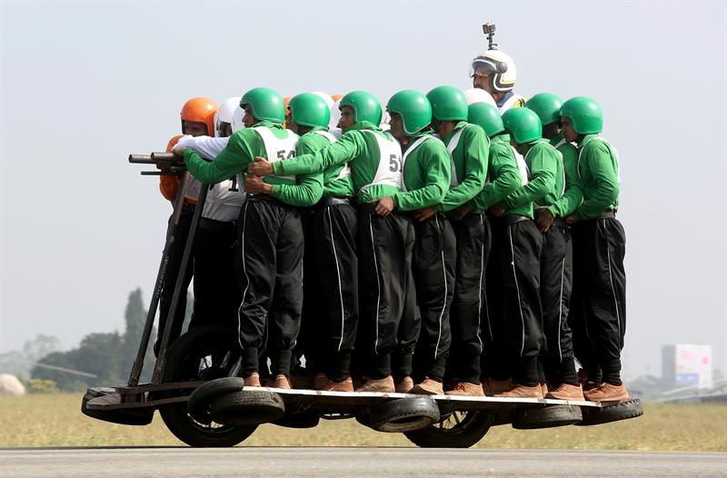 Los integrantes del equipo de exhibición de motocicletas del Cuerpo de Servicio del Ejército (TAC) se atornillan mientras intentan romper un récord mundial en la Estación de la Fuerza Aérea Yelahanka, en Bangalore. EFE