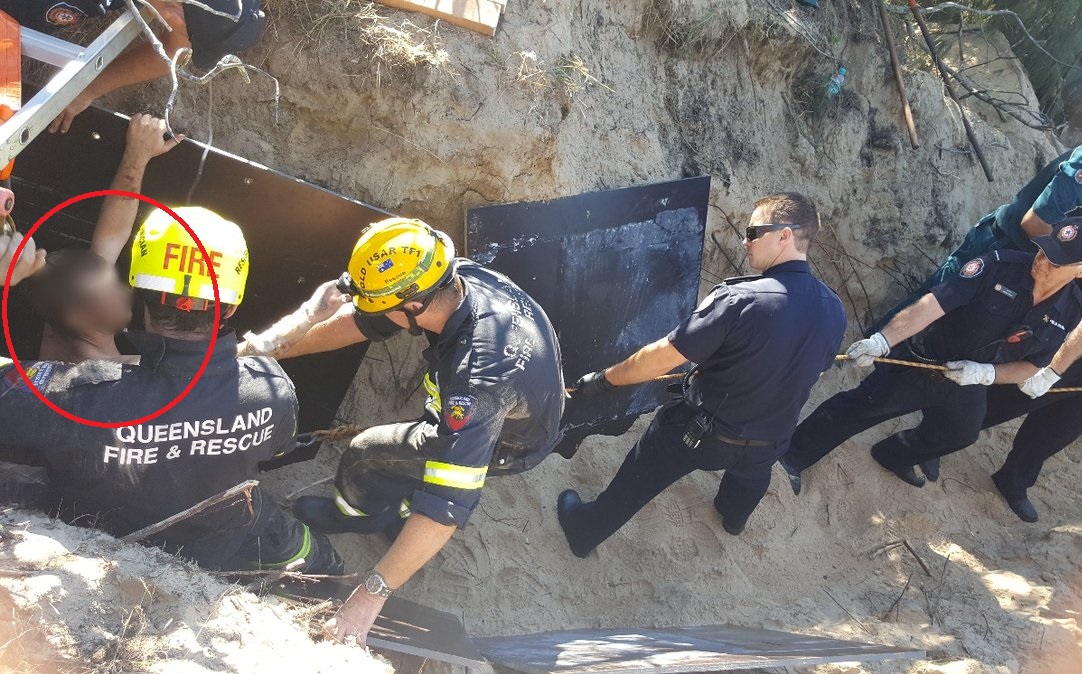 La arena se derrumbó alrededor de él en la playa de Urangan. Foto:   @QldPolice  