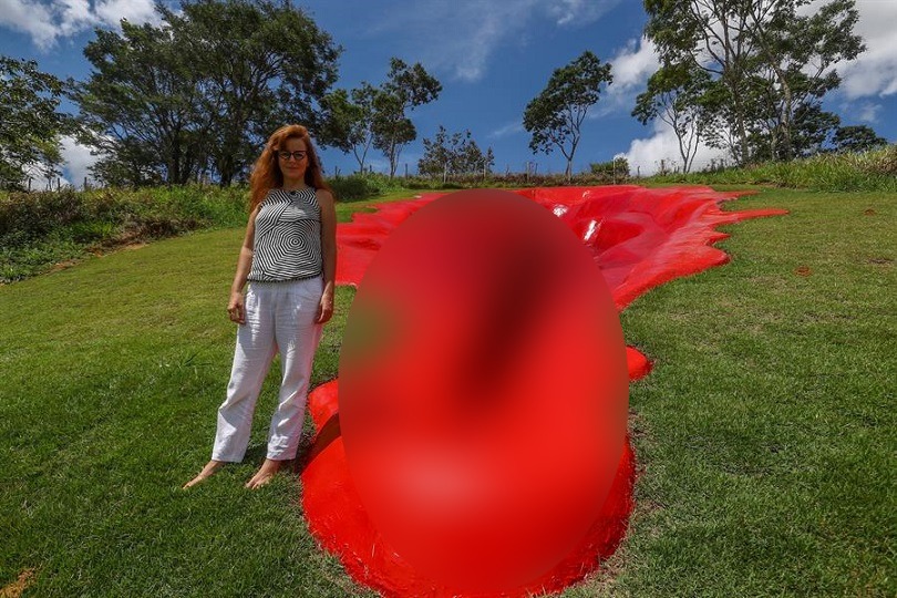 La artista Juliana Notari posa junto a su escultura esculpida en una pequeña montaña del ecosistema Mata Sul, estado de Pernambuco (Brasil). EFE