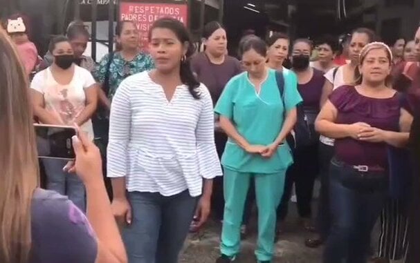 Comunidad educativa protesta en la parte exterior de la escuela.