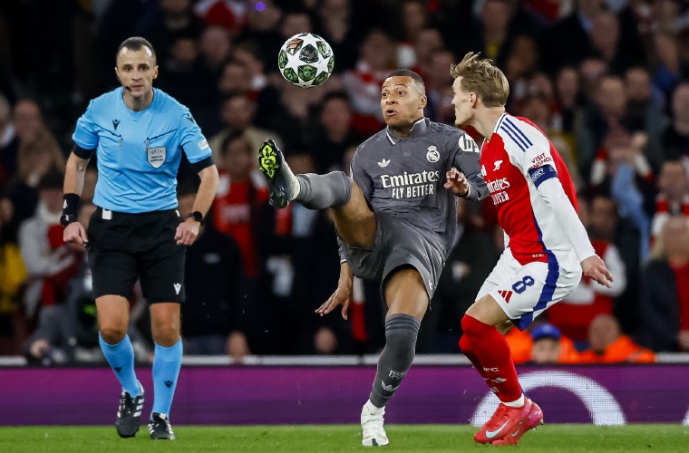 Martin Odegaard, del Arsenal, marca al atacante Kylian Mbappé, del Real Madrid.