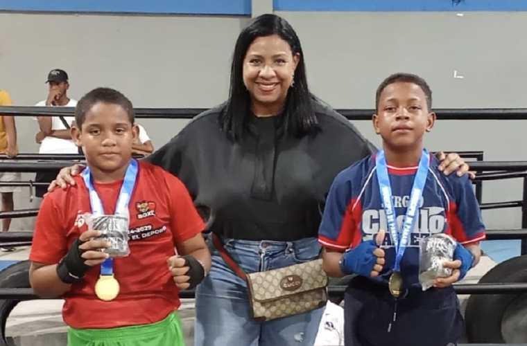 La promotora Rouss Laguna junto a dos de los niños participantes de la cartilla de boxeo olímpico.