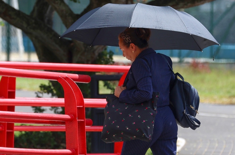Una persona se cubre del sol con una sombrilla en la Cinta Costera este martes. 