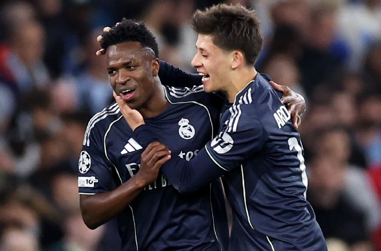 Vinicius Junior (C), celebra con Arda Güler uno de sus dos goles anotados ante el Manchester City.