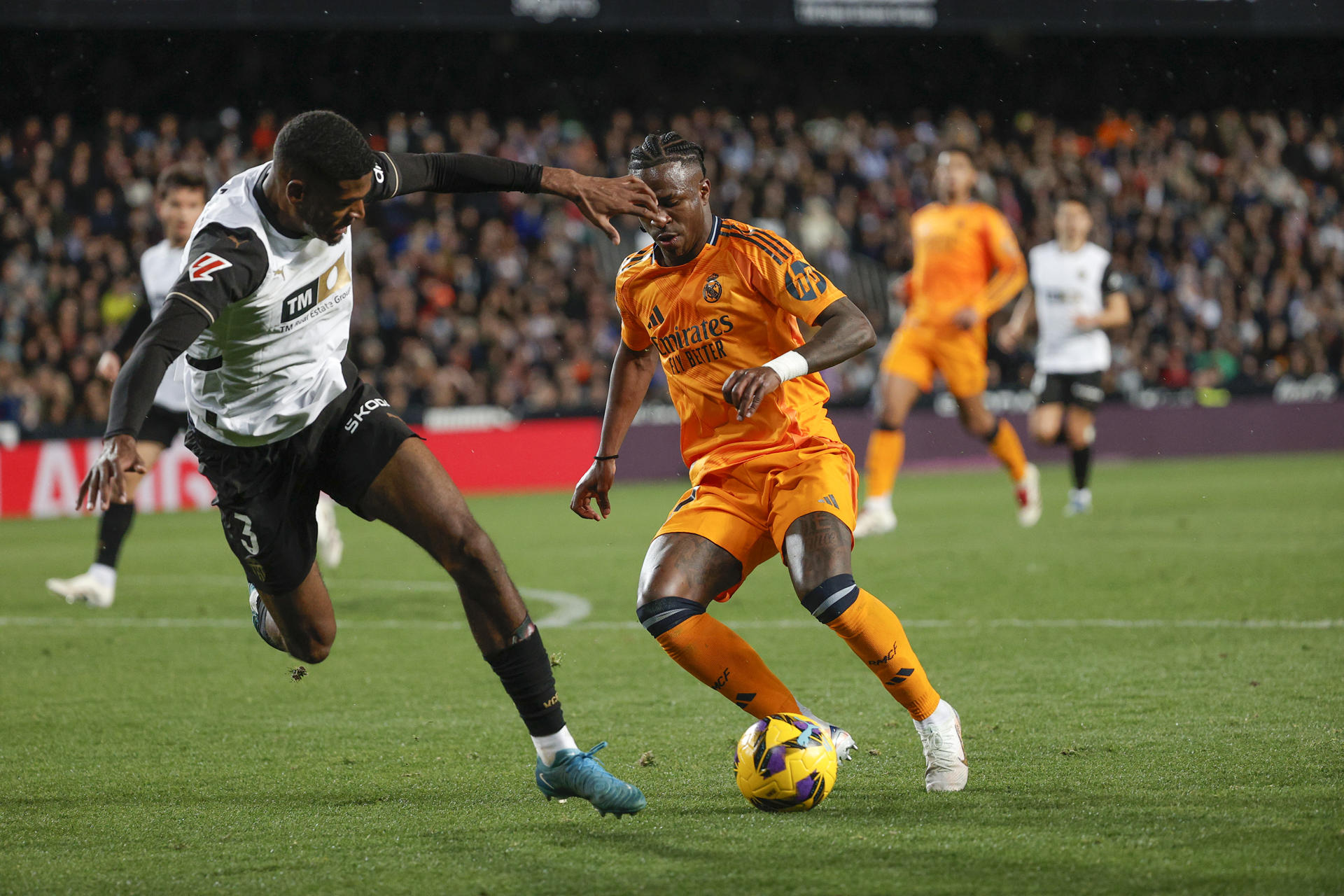 Vinicius Jr. (d) lucha con Cristhian Mosquera (i), del Valencia. /Foto: EFE