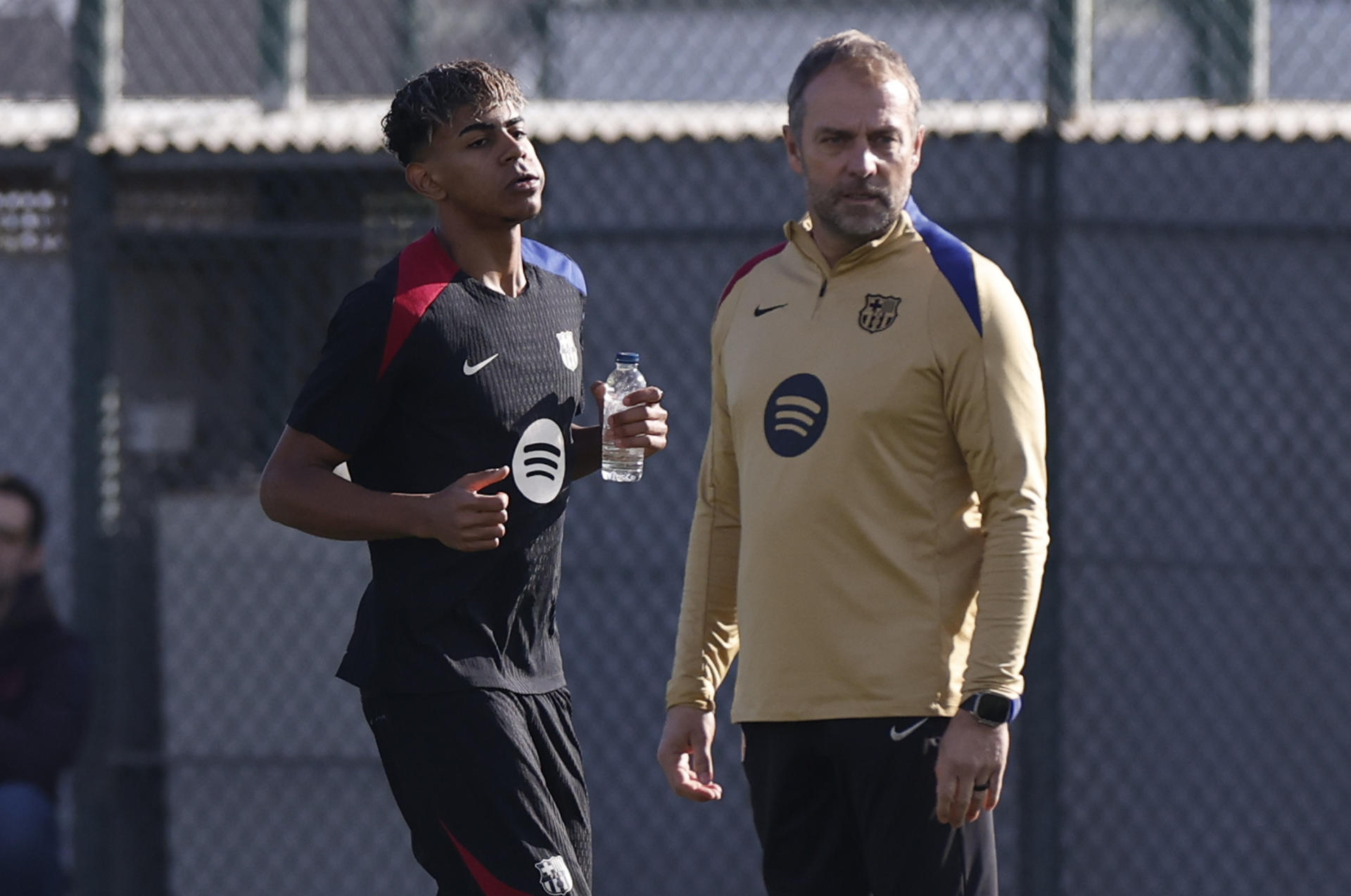 El entrenador del FC Barcelona, Hansi Flick, junto a Lamine Yamal durante el entrenamiento que el equipo azulgrana. /Foto: EFE