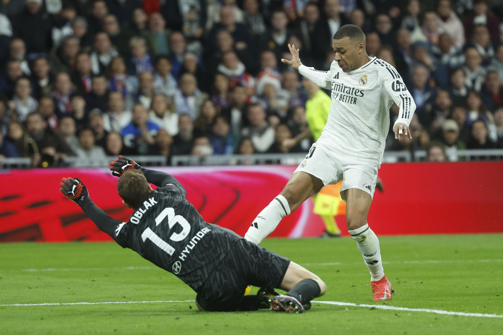 Kylian Mbappé (d) trata de superar al portero Jan Oblack. /Foto:EFE