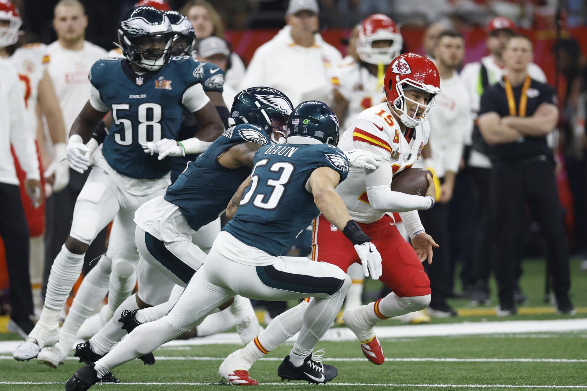 El quarterback Patrick Mahomes (R) trata de evadir a la defensiva de los Eagles. /Foto: EFE