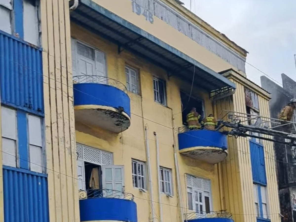 Bomberos atienden el incendio que se originó el parte superior de edificio.