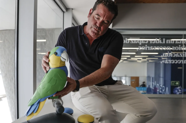 El loro Onorato IA con su creador, Pablo Mariñosa. Foto: EFE