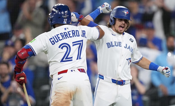 Addison Barger (der.) es saludado por Vladimir Guerrero Jr., luego de conectar un jonrón con bases llenas. Foto: EFE