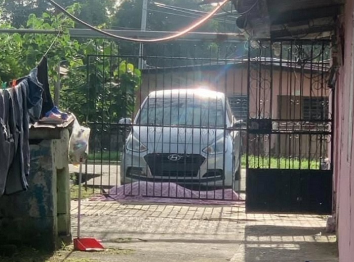 Su cadáver del hombre quedó tendido entre un sedán de color gris y la verja de entrada de la vivienda.  /  Foto: memeslabpty 