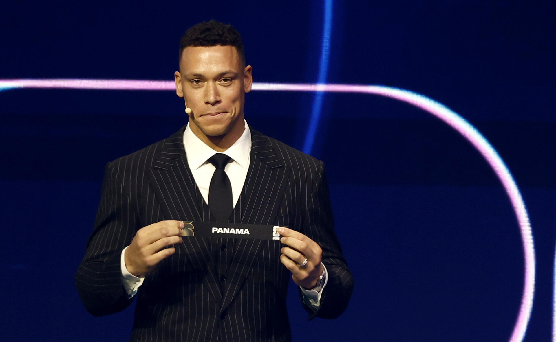 El asistente de sorteo Aaron Judge sostiene el boleto de Panamá durante el sorteo de la Final de la Copa Mundial de la FIFA 2026. /Foto: EFE