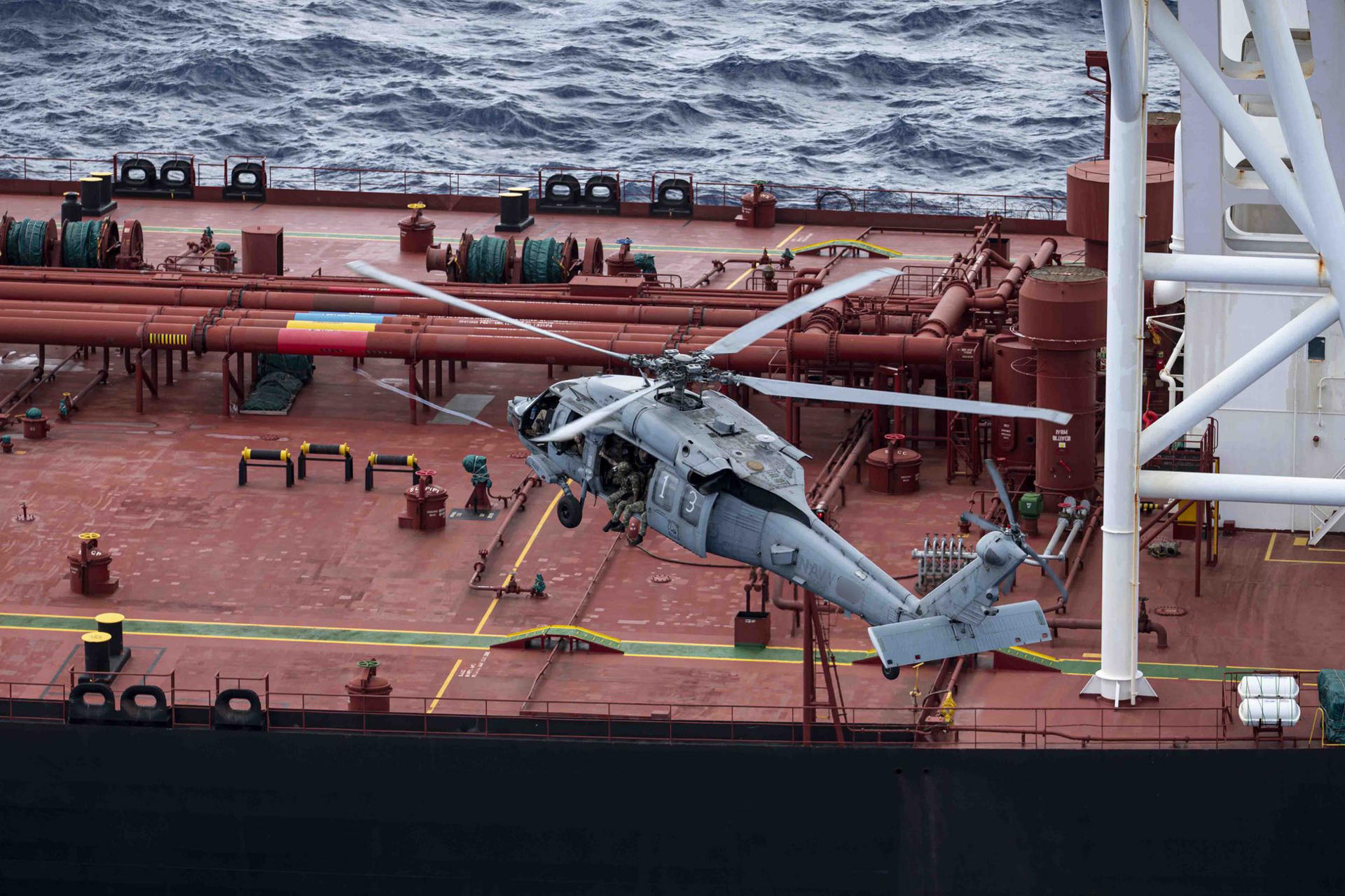 Fotografía difundida en la cuenta oficial en X @DeptofWar del Departamento de Guerra de Estados Unidos de uno de sus helicópteros interceptando un buque petrolero en el océano Índico. 