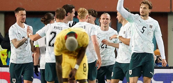 Jugadores de Austria celebran ante el lamento de un jugador de Ghana.