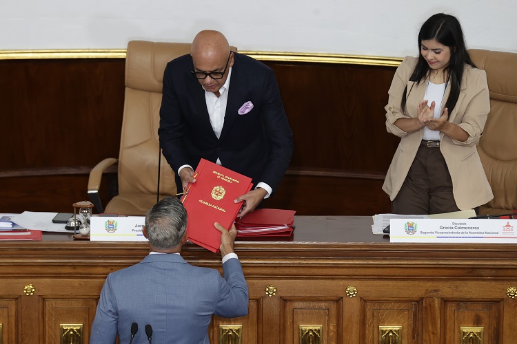 El diputado a la Asamblea Nacional (AN) Giuseppe Alessandrello (Abajo) entrega al presidente de la Asamblea Nacional de Venezuela, Jorge Rodríguez, el informe del Comité de Evaluación de Postulaciónes del Poder Ciudadano para la designación del defensor del pueblo y el fiscal general este jueves, en Caracas (Venezuela). Foto. EFE