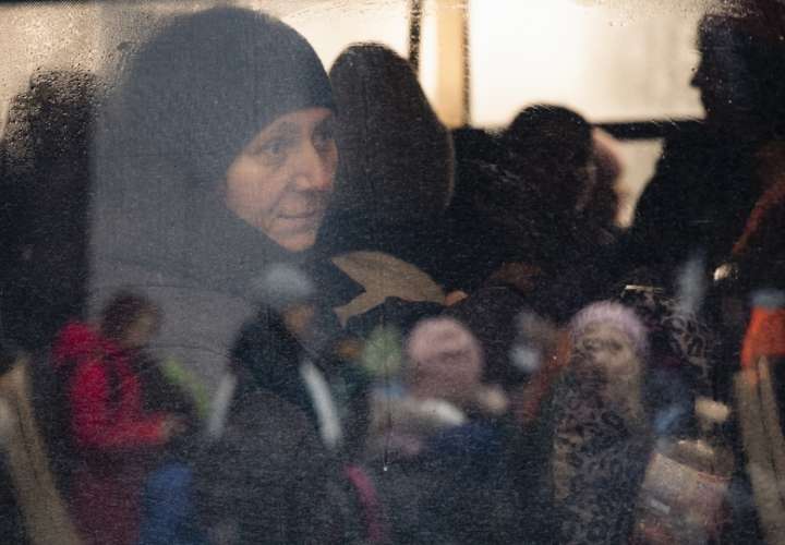 Una mujer, vista a través de la ventana de un autobús, observa durante la evacuación de civiles a Kiev, llevada por combatientes de defensa territorial, en la pequeña ciudad de Irpin, cerca de Kiev. EFE