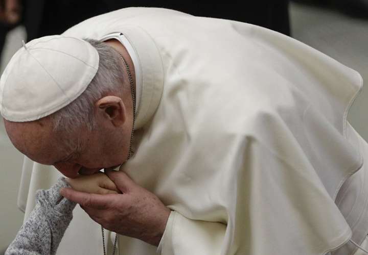 El Papa Francisco besa la mano de un niño durante la audiencia general semanal en el Vaticano. Foto: AP 