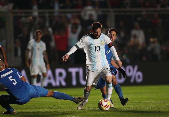 Leonel Messi (c) disputa un balón con Renato Punyed de Nicaragua. Foto: EFE