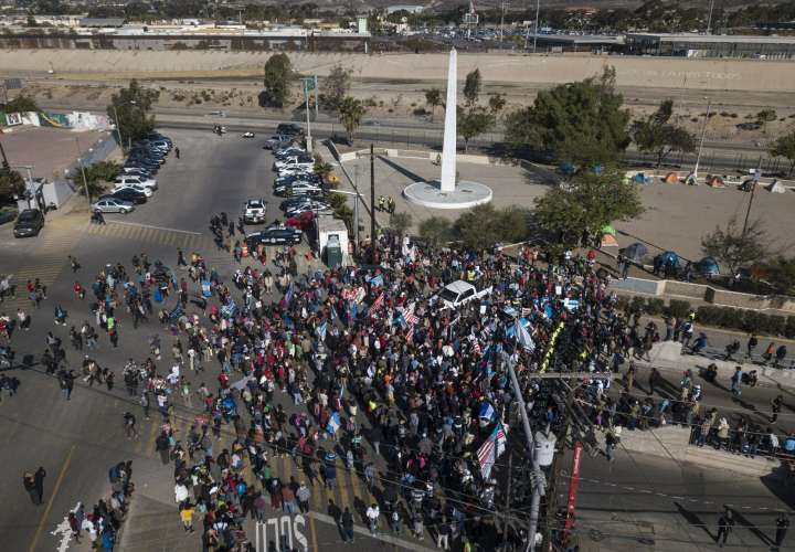 Migrantes se reúnen en el cruce fronterizo Chaparral, entre Tijuana, México y EE.UU.  Foto: AP
