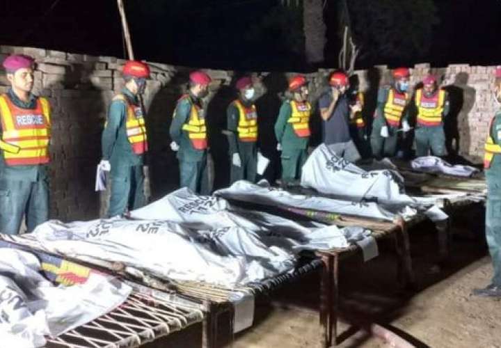 La policía de Pakistán con los cadáveres de las mujeres y los niños incinerados presuntamente por un padre molesto con la boda de una de ellas. 