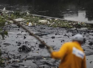 Un hombre   limpia el río Meriti, que desemboca en la Bahía de Guanabara, sede de las pruebas de Vela en los Juegos Olímpicos de Río 2016. Foto EFE