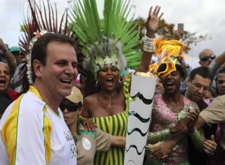 El alcalde de Río de Janeiro, Eduardo Paes (i), recibe la antorcha olímpica. Foto EFE