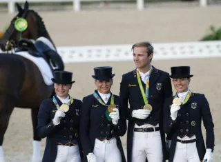 Los jinetes alemanes Isabell Werth, Kristina Broring-Sprehe, Sonke Rthenberger y Dorothee Schneider lucen sus medallas doradas. Foto EFE
