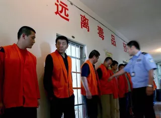 Un policía cachea a los drogadictos de un centro de rehabilitación forzada de la ciudad de Gongzhuling, en la provincia del noreste chino de Jilin. EFE/Archivo
