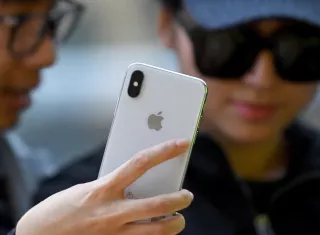 Fotografía de archivo tomada el 13 de noviembre de 2017 que muestra a una joven que observa el iPhone X tras su salida a la venta en una tienda Apple en Sídney (Australia). EFE