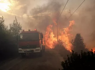 Bomberos tratan de extinguir un incendio en Penteli, al norte de Atenas (Grecia), hoy. EFE