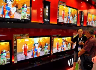 Una mujer intenta vender un televisor en Qingdao, China. EFEArchivo