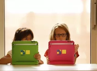 Dos niñas utilizan sus tabletas. EFE