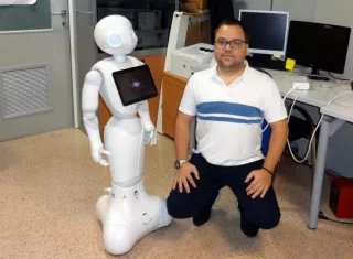 En la imagen, facilitada por la Universidad Minho, Ângelo Costa, uno de los investigadores lusos, junto al robot. EFE