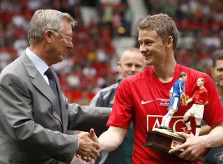El noruego Ole Gunnar Solskjaer (rojo) estrecha la mano de su extécnico en el Manchester United, Sir Alex Ferguson. /AP