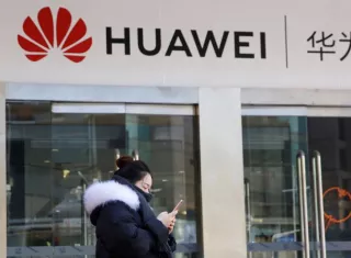 Una joven utiliza su teléfono móvil ante una tienda de la firma china Huawei en Pekín, China, EFE/Archivo