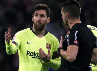 El delantero argentino del F.C Barcelona Leo Messi (i) ante el árbitro Del Cerro Grande./ EFE