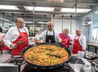 El chef español Enrique García enseña a cocineros de comedores escolares cómo cocinar paella durante un taller en Praga (República Checa). EFE/Archivo