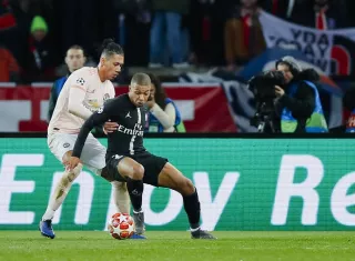 Kylian Mbappe, atacante del PSG, es marcado por el defensor del Manchester United, Frederico Fred. /AP