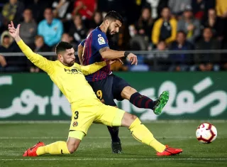 El delantero uruguayo del FC Barcelona Luis Suárez (d), dispara a puerta frente al defensa del Villarreal CF Álvaro González. Foto: EFE